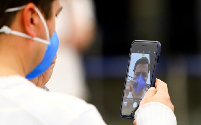 hombre-cubrebocas-toma-foto-celular